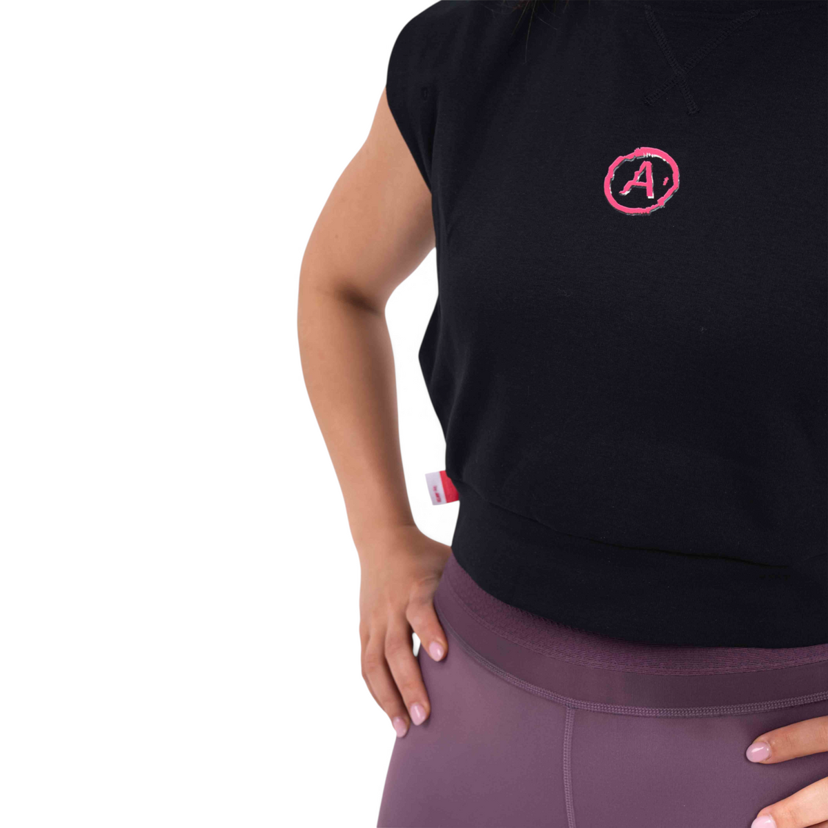 FRG black short sleeve cropped tee with a pink circular logo graphic and ribbed hem worn with purple leggings
