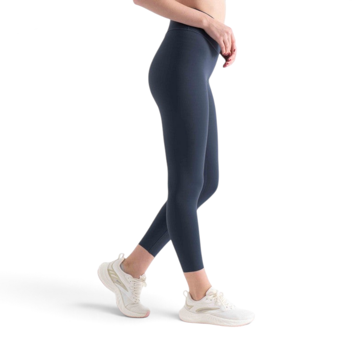 FRG tight ankle pants in dark grey worn by a woman with white athletic sneakers against a plain white background