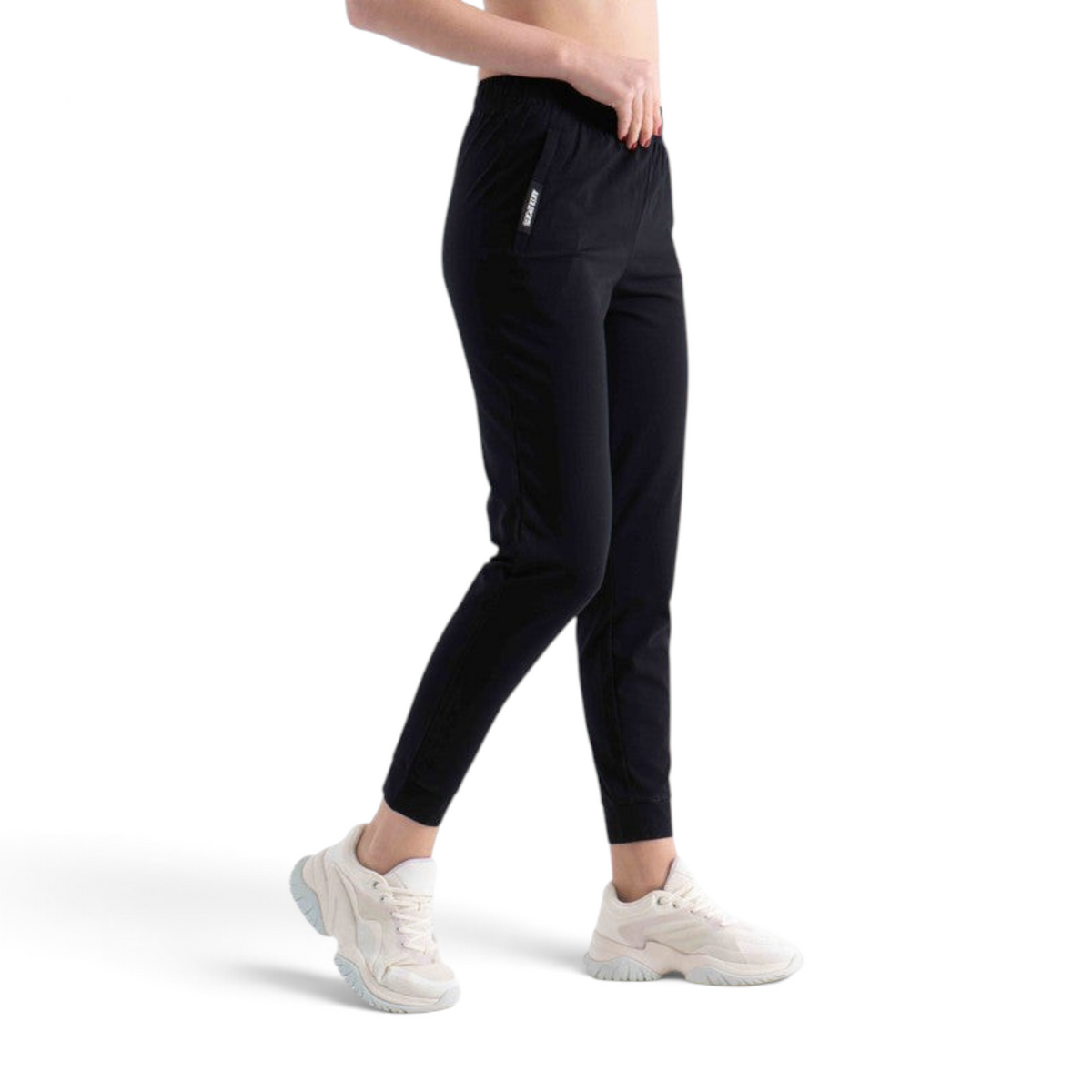 FRG black knit track pants with an elastic waistband and cuffed ankles worn by a model with white sneakers