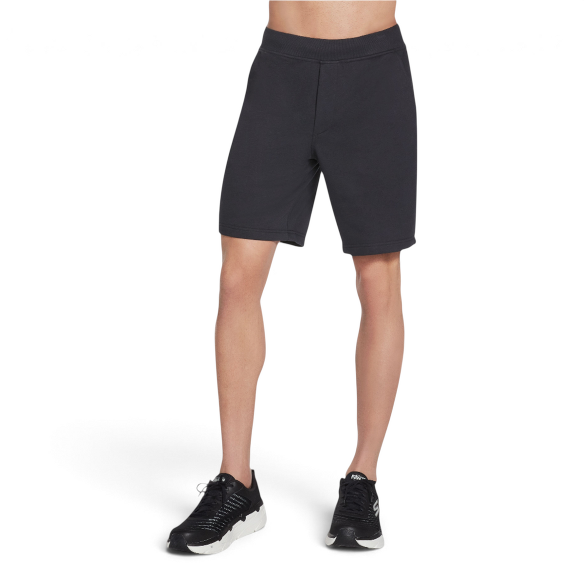 FRG men's black knit shorts with an elastic waistband, worn by a model with black athletic sneakers.
