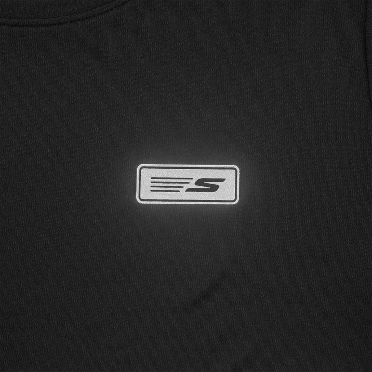 FRG black shortsleeve tee featuring a reflective rectangular logo patch on the chest