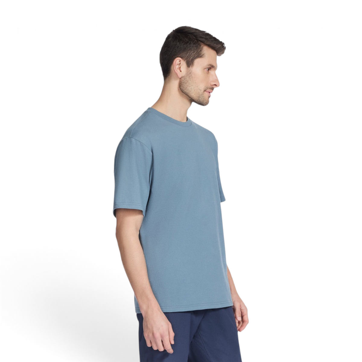 A man wearing a blue FRG SKECH-JERSEY MAX short sleeve crew neck t-shirt in a studio setting