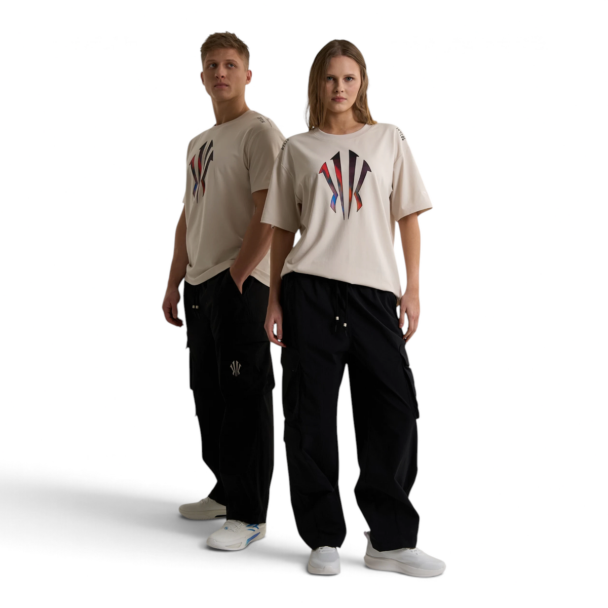FRG ANTA black woven casual basketball pants worn by a man and woman with matching beige graphic t-shirts